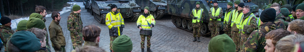 Group of soldiers standing in front of a number of armored vehicles