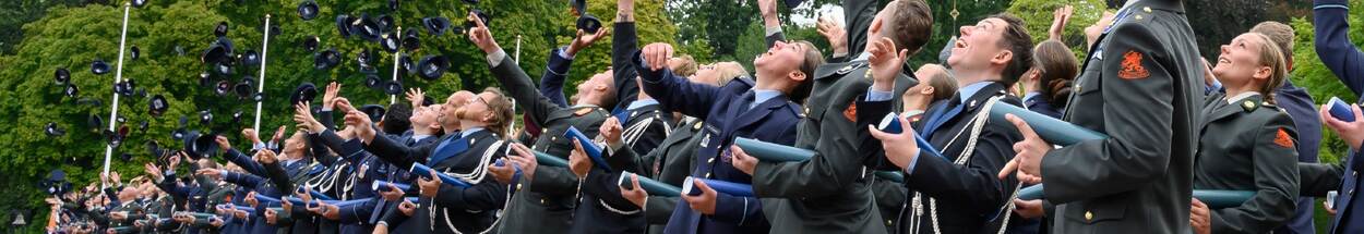 Military throw their beret in the air during graduation.