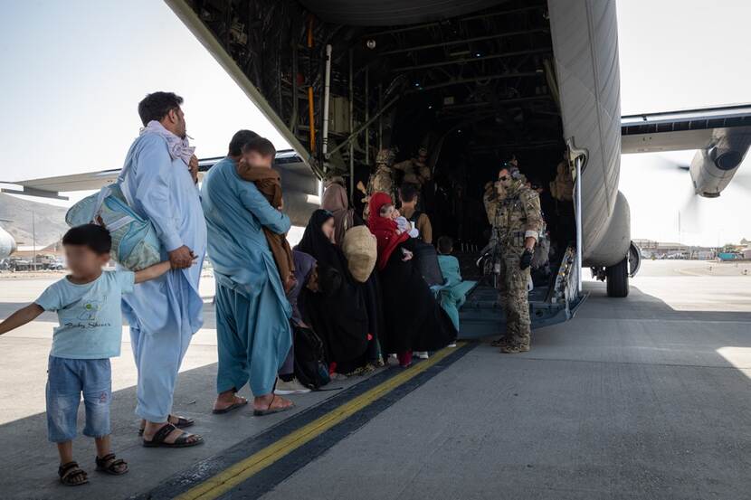 Families enter a plane for evacuation.