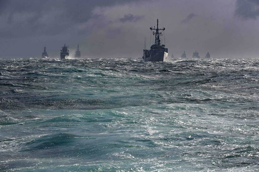 A navy ship on a wild sea.