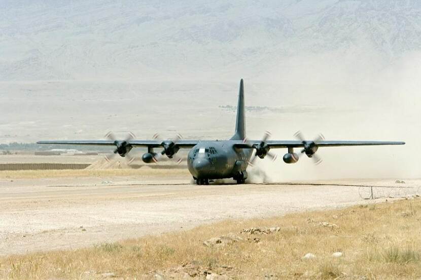 A Hercules C-120 lands on a runway.