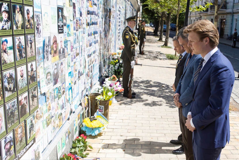 Minister of Defence Brekelmans at a wall of remembrance with pictures of Ukrainian soldiers who died in the war.