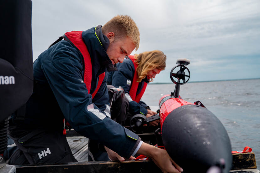Two people on water with the scout drone