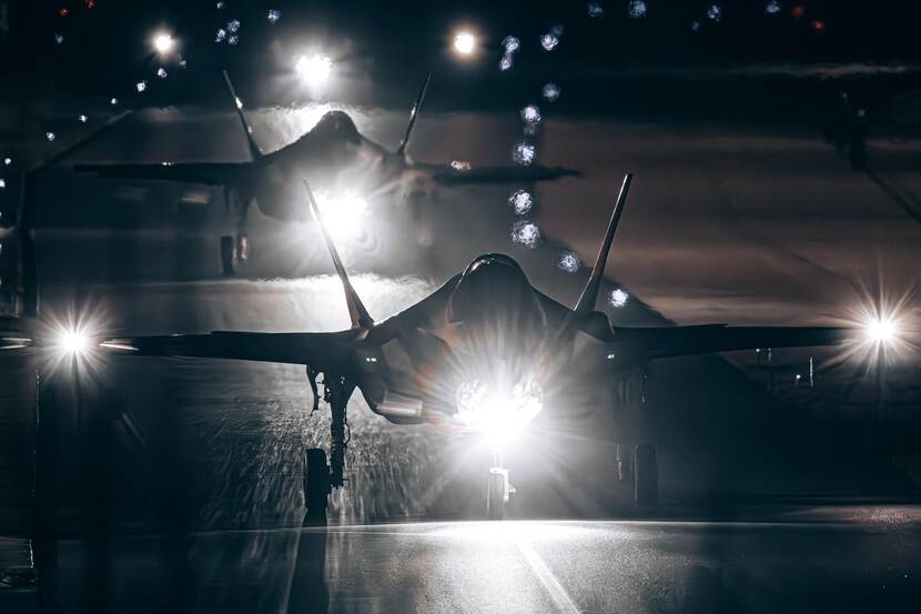 Two F-35's flying in the dark