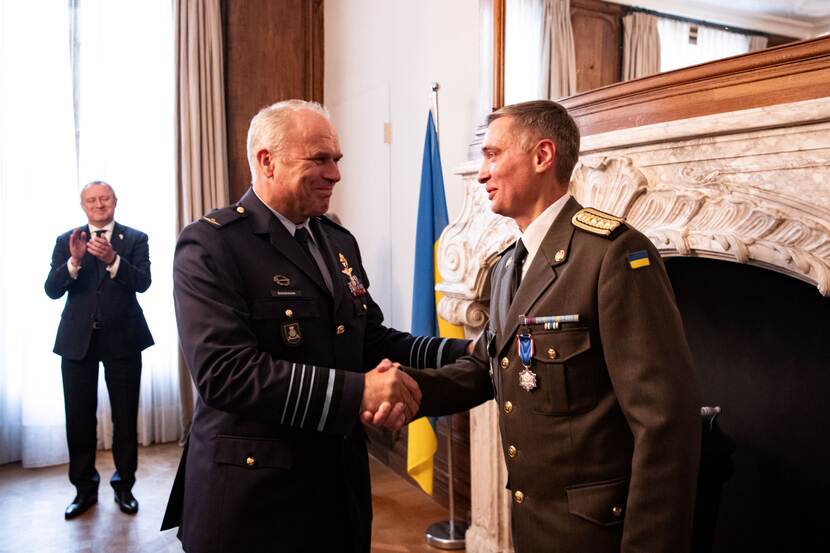 CDS Onno Eichelsheim congratulates Ukrainian defence attaché  Yurii Herashchenko met zijn Ereteken voor Verdienste in het Zilver. Op de achtergrond de ambassadeur van Oekraïne .