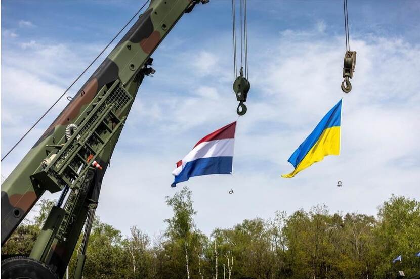 Dutch and Ukrainian flags, hanging from a crane.