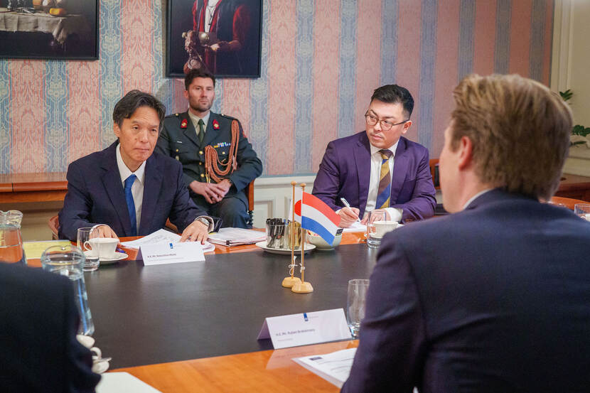 The Japanese ambassador and the Dutch minister of Defence are in a meeting sitting around a table.