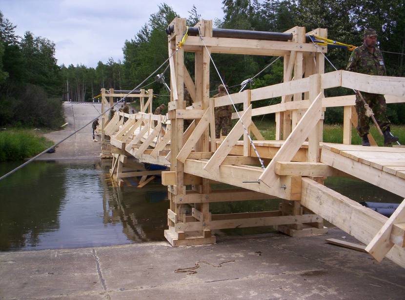 Soldiers building a wooden bridge.