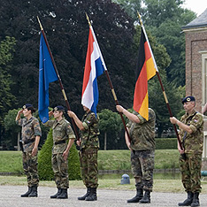Soldiers with the German and Dutch flags and the flag of the United Nations.