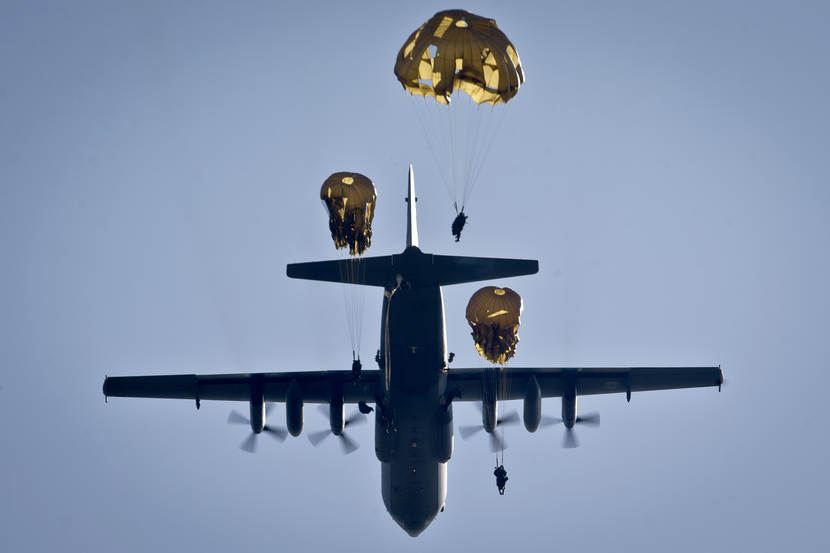 As seen from the ground:  paratroopers of the 11 Airmobile Brigade exit a Hercules C-130 transport aircraft via the rear ramp.