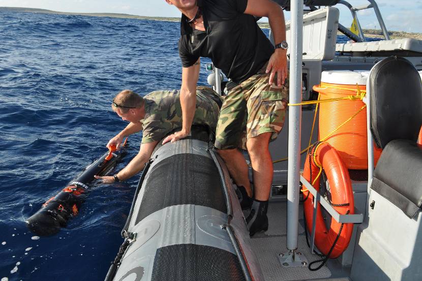 Military personnel use underwater equipment to monitor the quality of the seawater in the Caribbean.