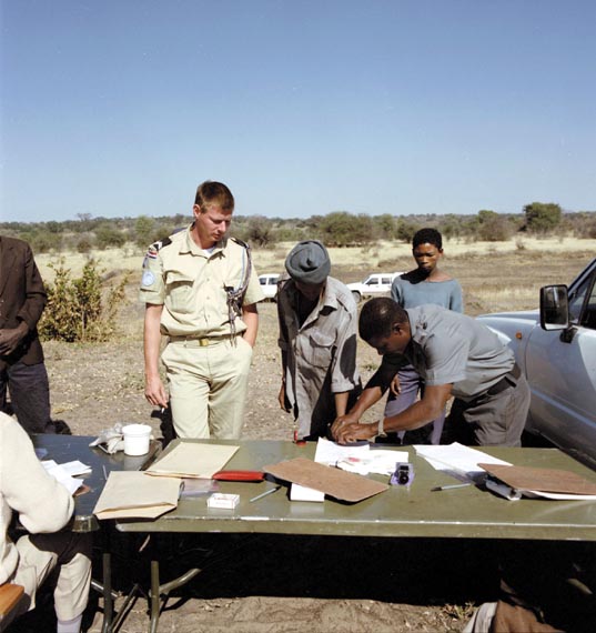 Sergeant 1 H. Lemmen of the Royal Netherlands Marechaussee watches how a Namibian citizen registers by fingerprinting in July 1989 to vote in the election to be held later in the year.
