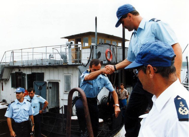 Shipping on the Danube was inspected by Italian and other patrol boats from June 1993. A Royal Netherlands Marechaussee official helps a foreign colleague aboard after an inspection.