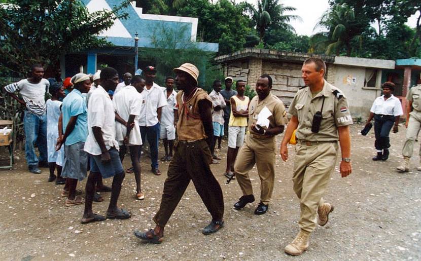 Sergeant Major P. Dijkstra helps a Haitian police officer bring in a man suspected of assault in February 1995.