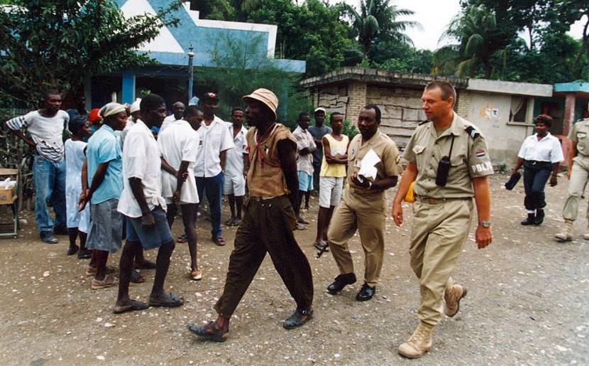 Sergeant Major P. Dijkstra helps a Haitian police officer bring in a man suspected of assault in February 1995.