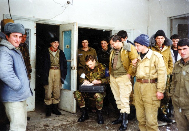 Major H.W. Verzijl (seated) visits a Georgian military post in South Ossetia early in 1996. Verzijl is taking notes on the strength and armament of the post.