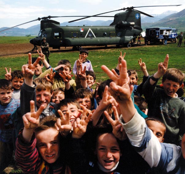 A Chinook transport helicopter delivers humanitarian relief aid to Kosovan refugees in the Fazdja refugee camp, northern Albania (May 1999).
