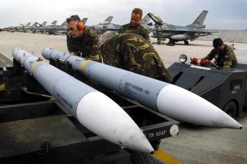 Royal Netherlands Air Force personnel take a close look at AMRAAM air-to-air missiles at Amendola air base in Italy. A Dutch F-16 pilot shot down a Yugoslavian MiG-29 Fulcrum fighter with one of these missiles on the first day of Operation Allied Force, May 1999.