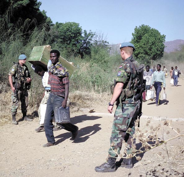 Marines keep an eye on proceedings during the handover of prisoners of war, early February 2001.