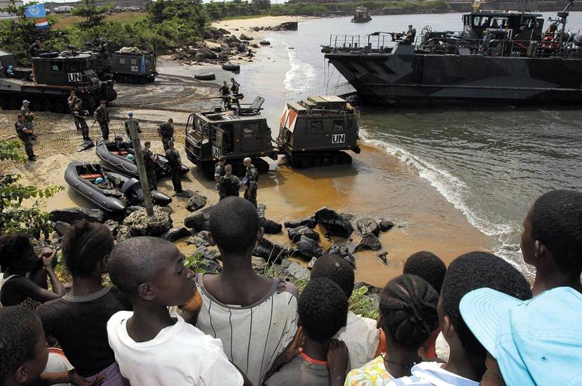 The people of Greenville (Liberia) watch how Ethiopian soldiers disembark from a landing craft. At the centre of the photo is a BV-206 tracked vehicle and, at top left, two Beach Armoured Recovery Vehicles for recovery and repair tasks.