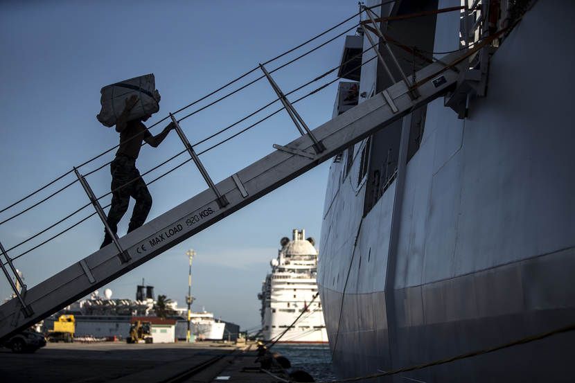 Navy personnel loading a ship.