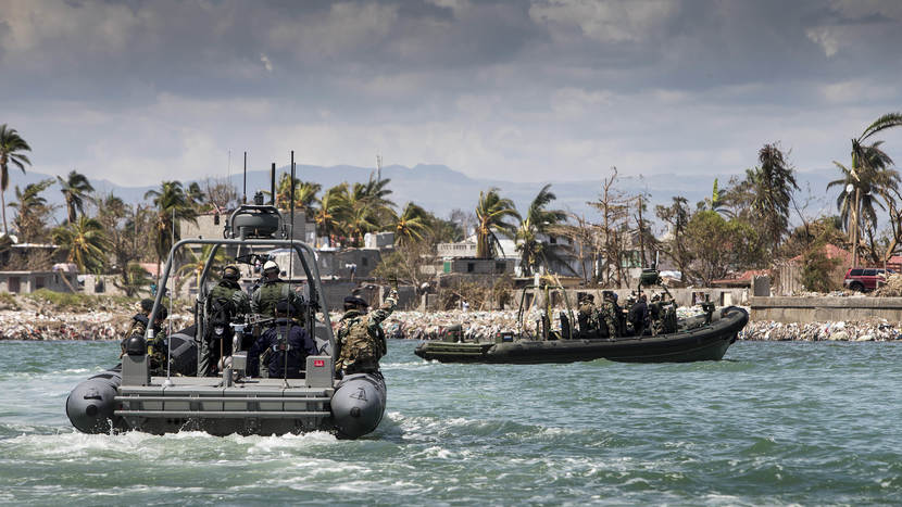 2 Navy RHIBs (fast motorboats) carrying marines to the devastated coastal area of Haiti.