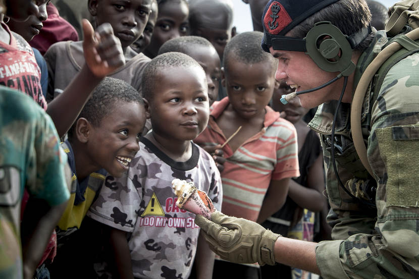 A marine talking to Haitian children.